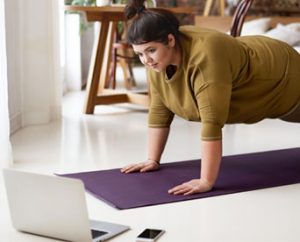 woman exercisinf at home with computer