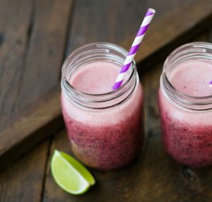 Two berry smoothies with a lime