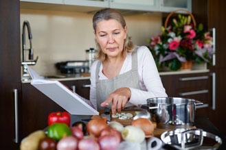 Woman reading recipe cooking in kitchen